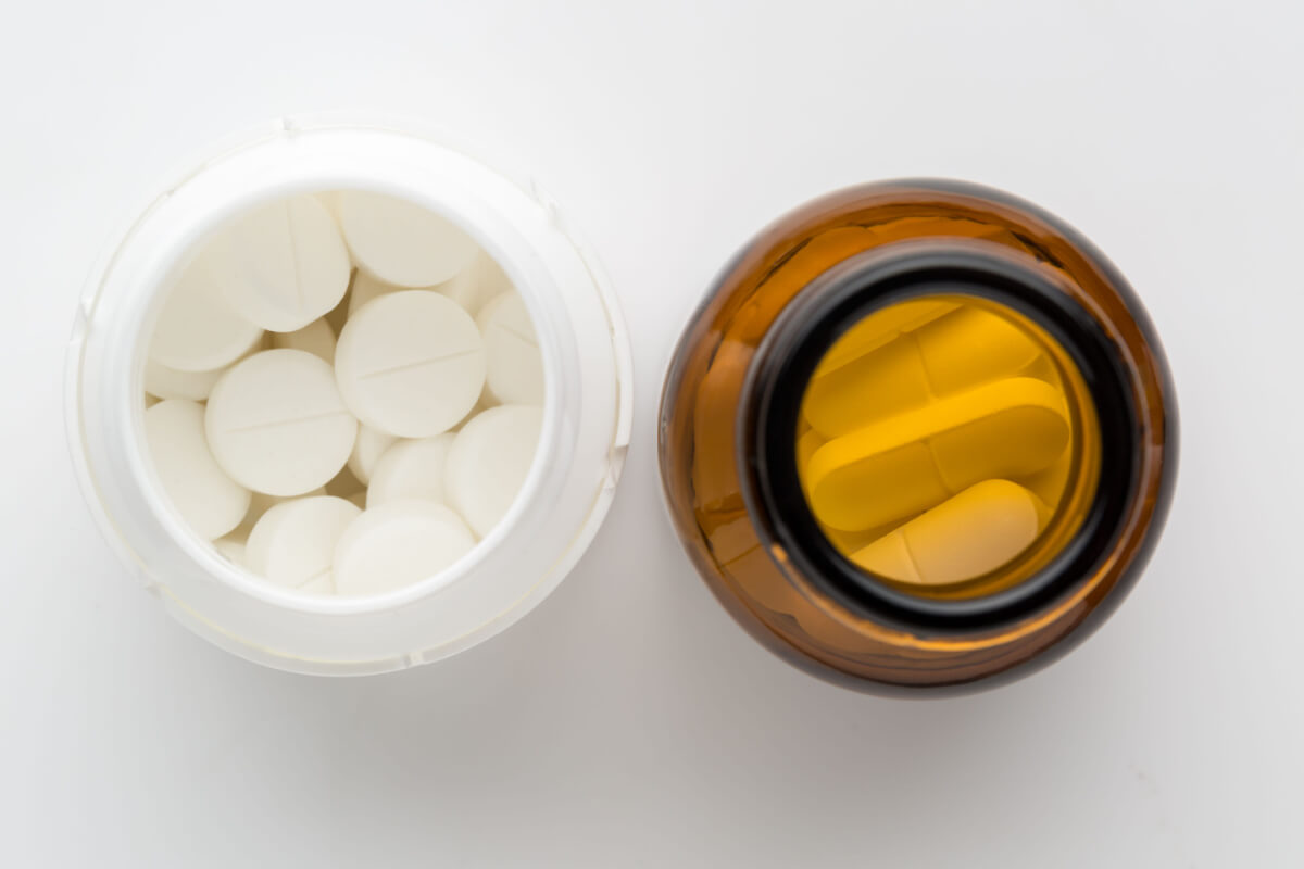 top view of two bottles of different pills. On white background.
