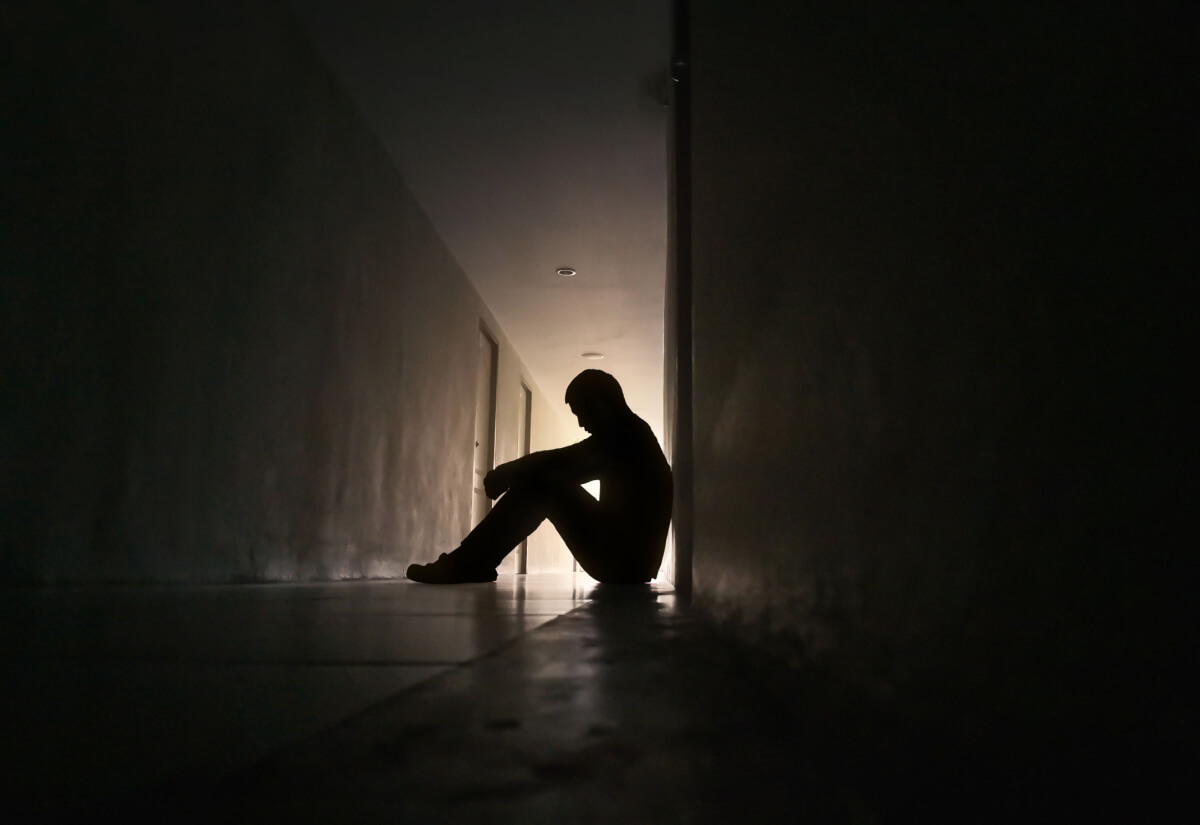 silhouette depressed man sitting on walkway