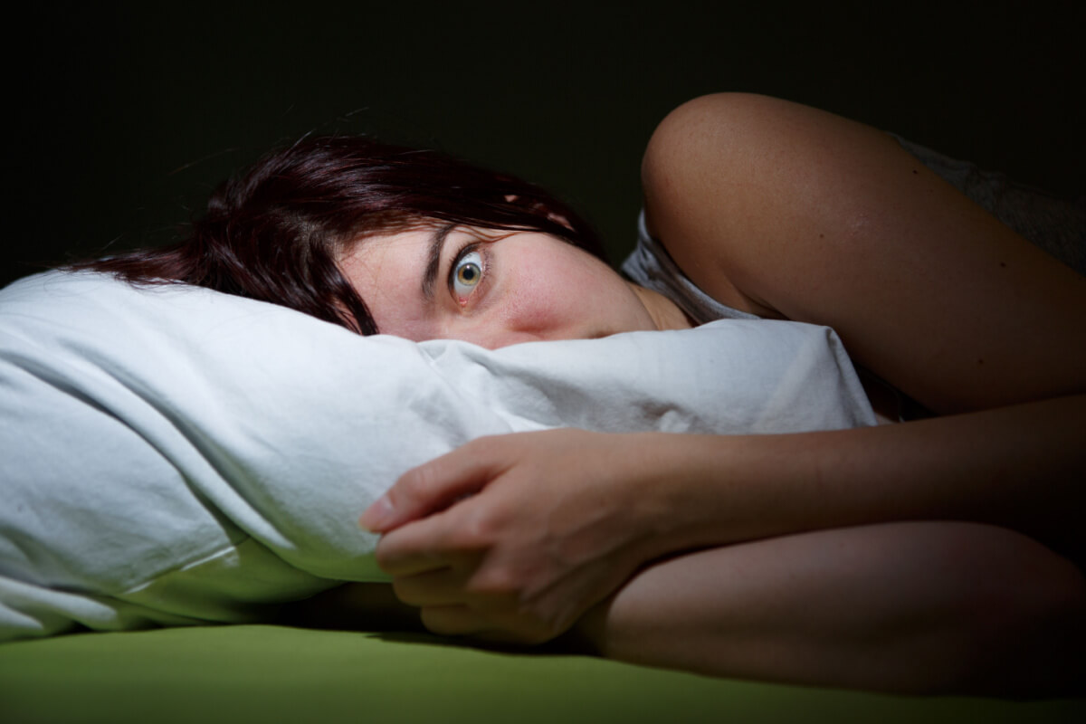 young woman in bed eyes opened