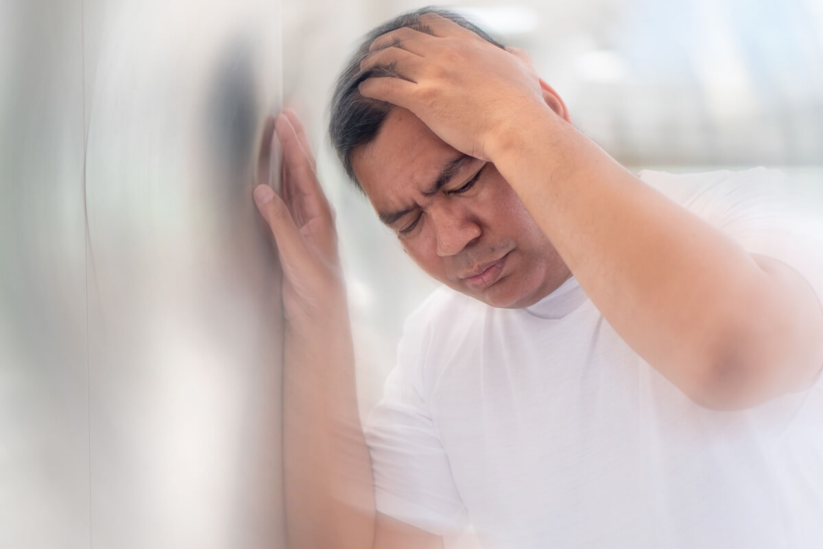 asian man experiencing dizziness
