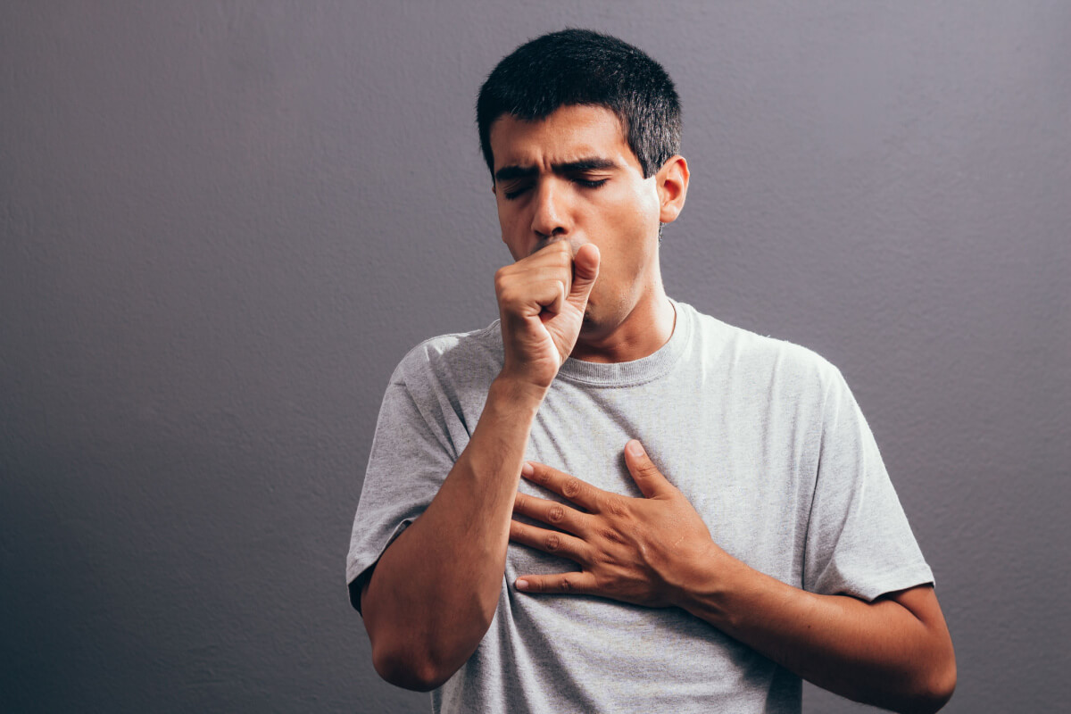 man coughing into fist