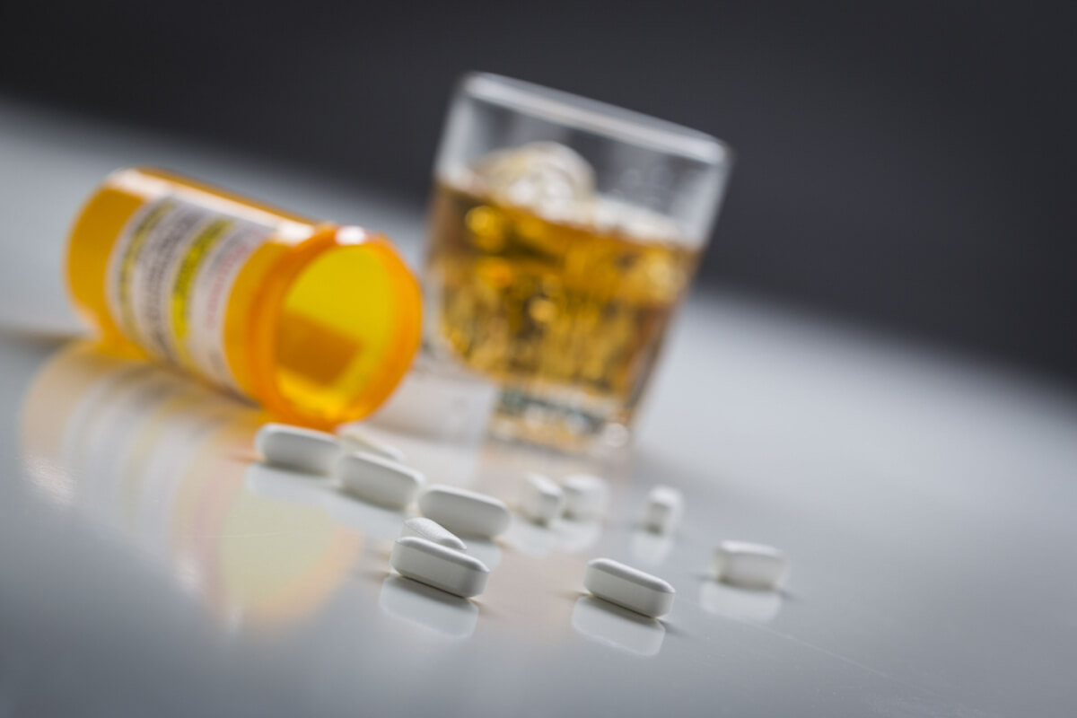 prescription pills with glass of alcohol