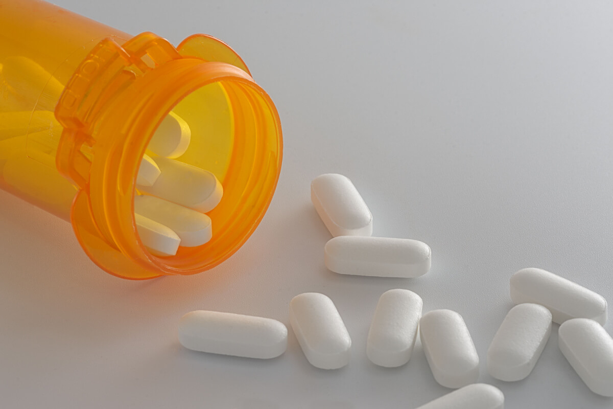 Bottle of prescription pills spilling out onto a white table