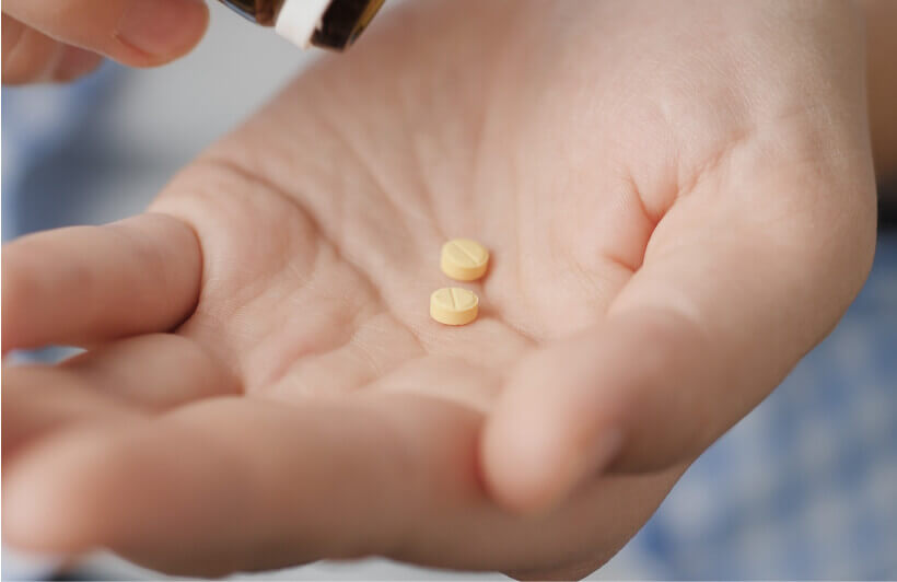 hand with two pills in it